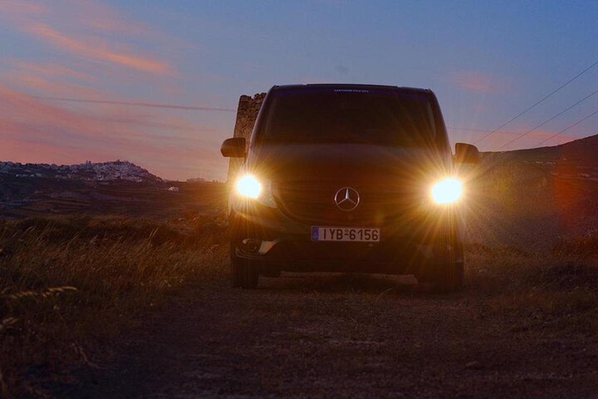 Una camioneta con los faros encendidos en un camino de tierra