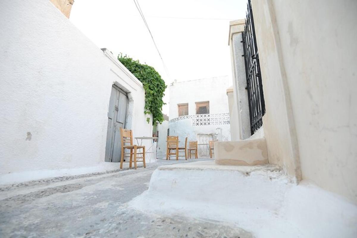 ένα σοκάκι με καρέκλες και ένα τραπέζι σε ένα κτίριο