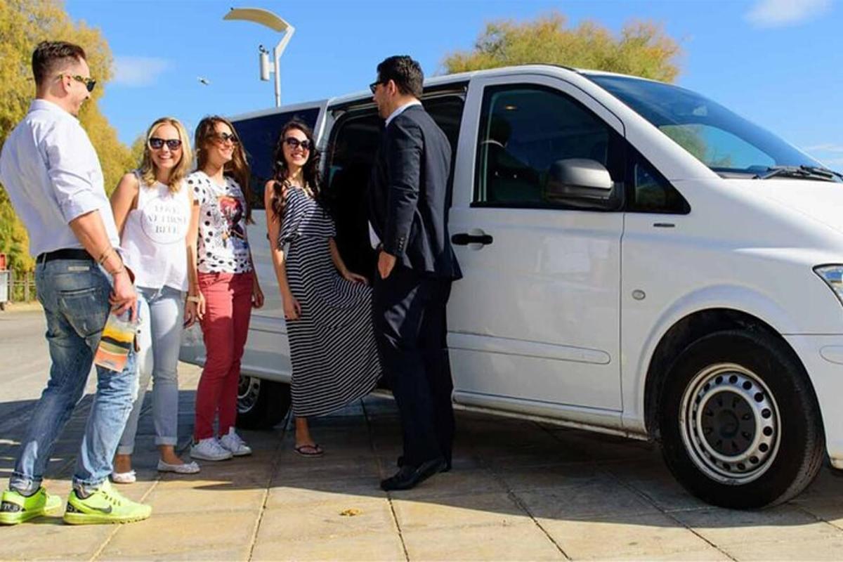 un grup de oameni care stă lângă o dubă albă