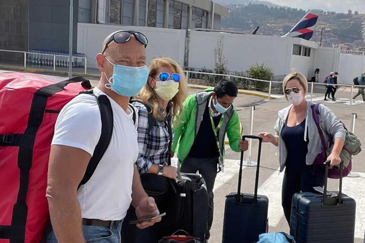 skupina ľudí s rúškami na letisku