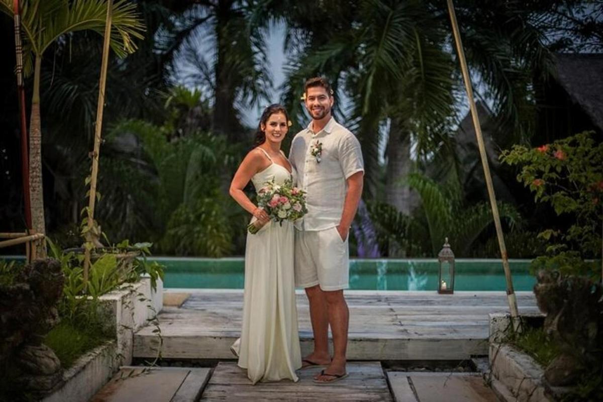 a bride and groom posing for a picture in front of a pool