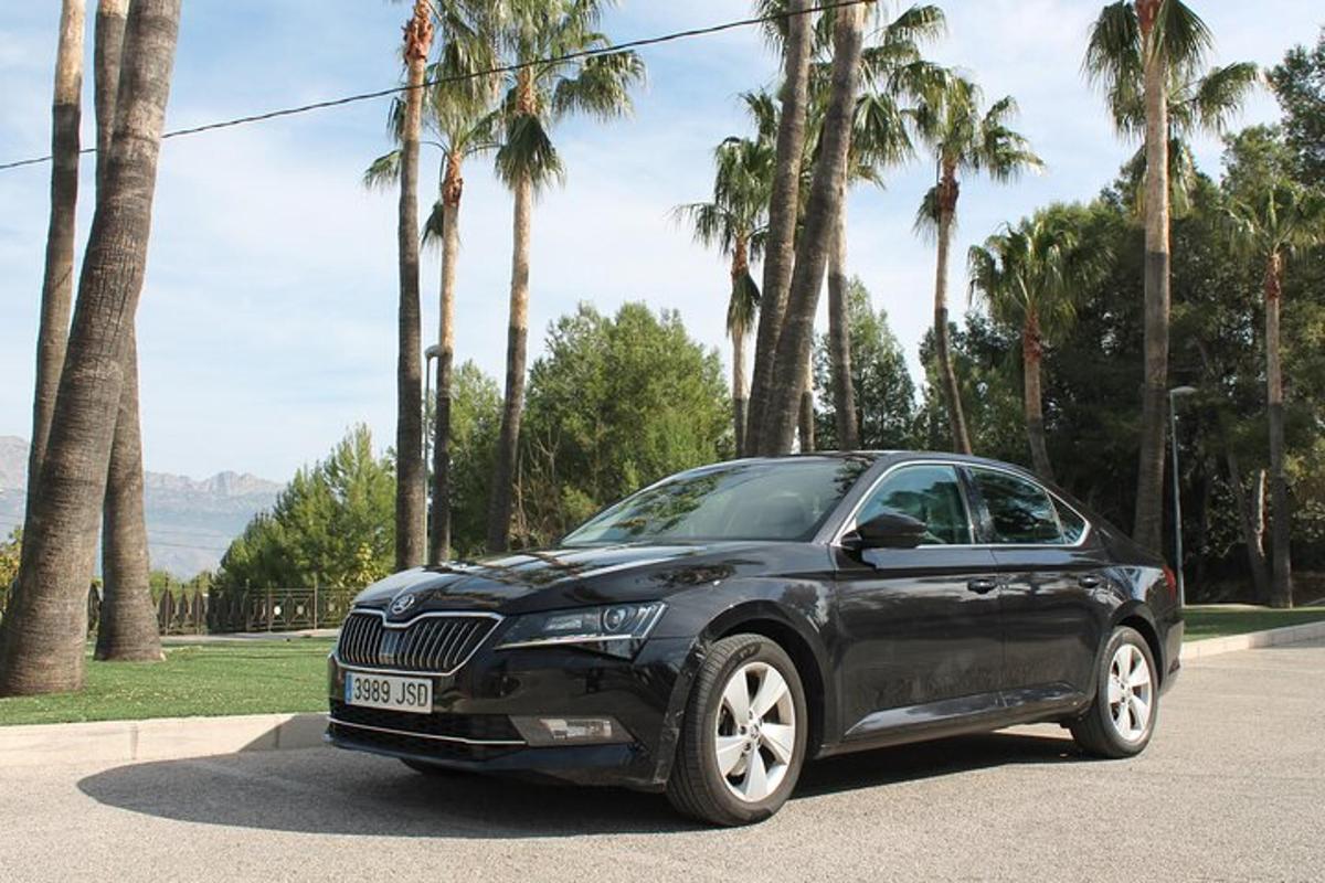un'auto nera parcheggiata in una strada con palme