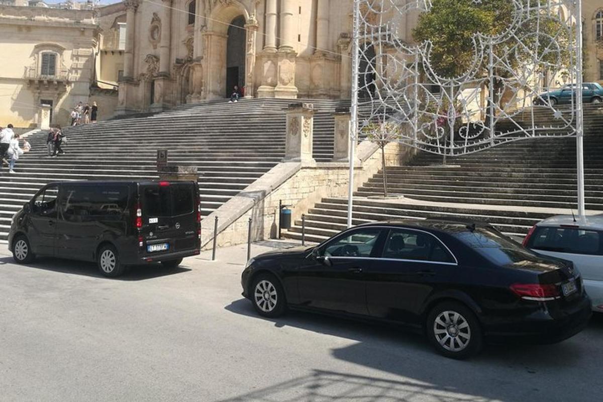 kaks autot pargitud trepiga hoone ette