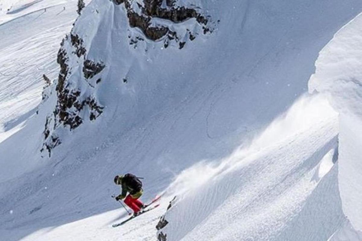 Una persona está esquiando por una montaña cubierta de nieve.