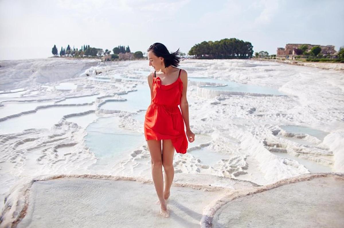 una donna in un vestito rosso che cammina sulla spiaggia