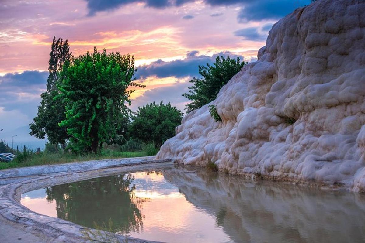 una pozza d'acqua accanto a una parete rocciosa