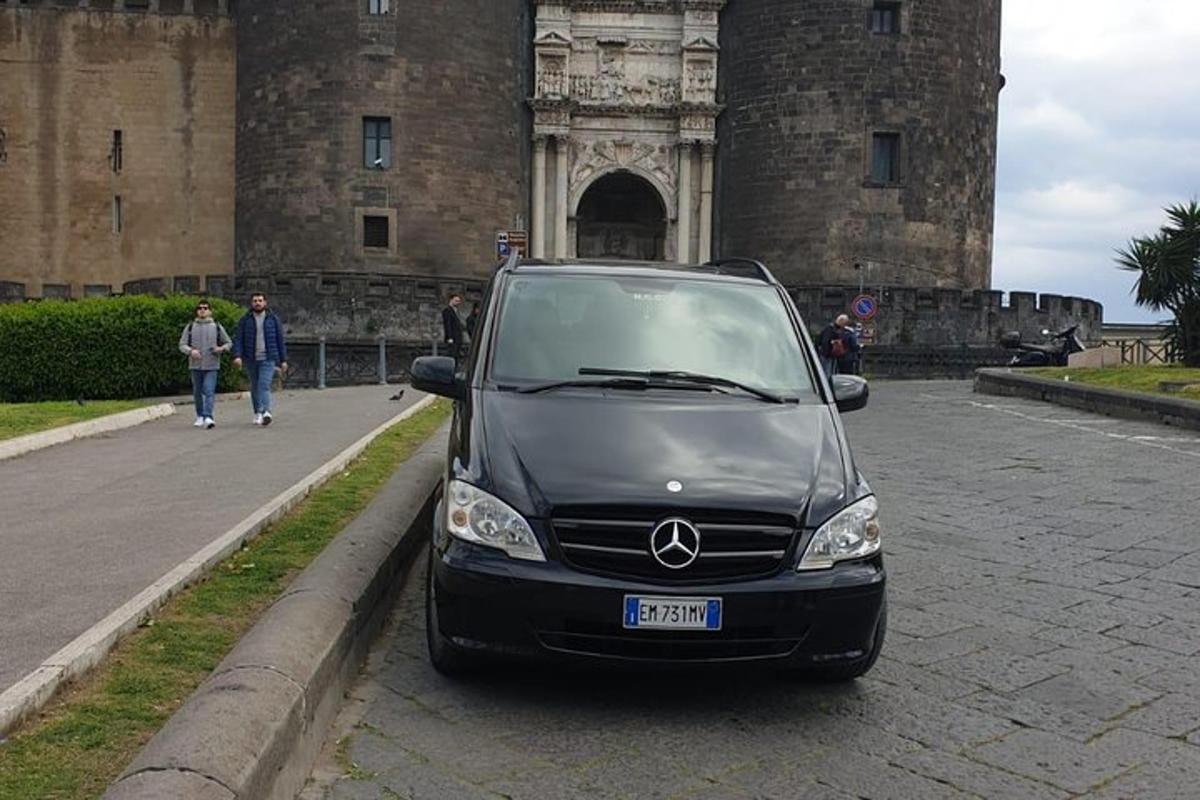 malé auto zaparkované před hradem