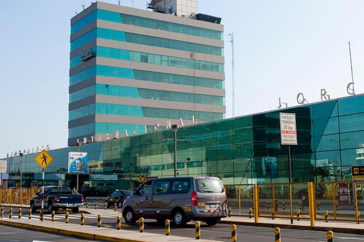 a large glass building with cars driving in front of it