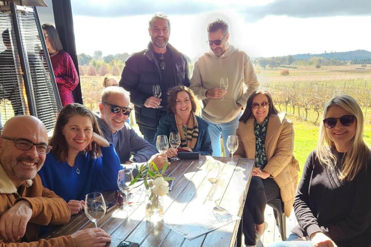 a group of people sitting around a table with wine glasses