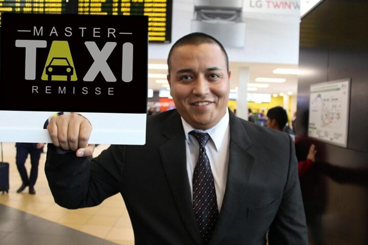 en man i kostym som håller en skylt där det står "master taxi remission"