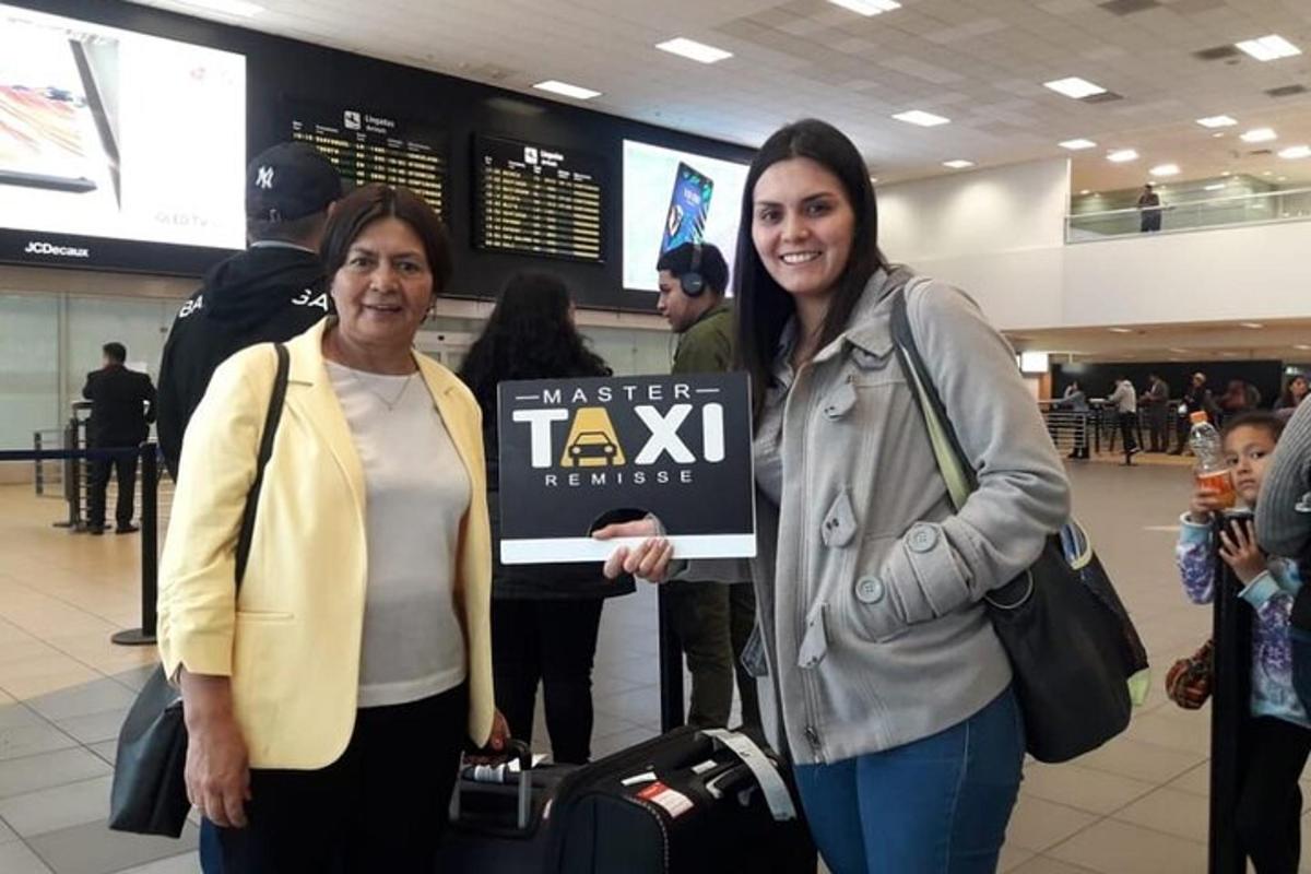 due donne in piedi in un aeroporto con un cartello in mano