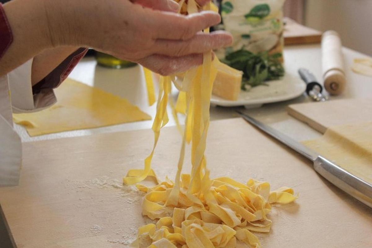 en person heller ost på en haug med pasta