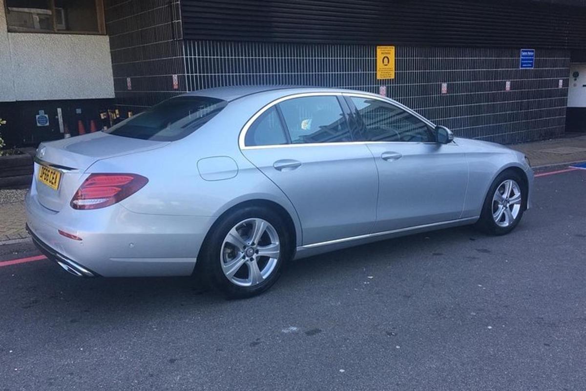 en sølvfarget bil parkert på en parkeringsplass