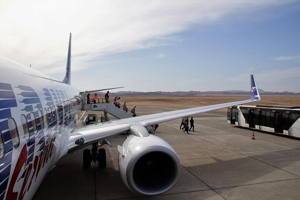 un grup de oameni care se îmbarcă într-un avion pe un aeroport