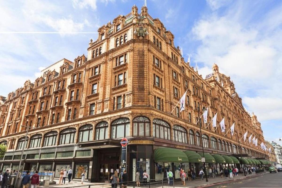 Un gran edificio en una calle con gente caminando al frente.