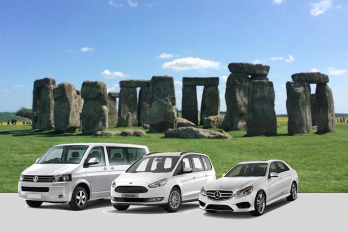 Skupina tří aut zaparkovaných před Stonehenge