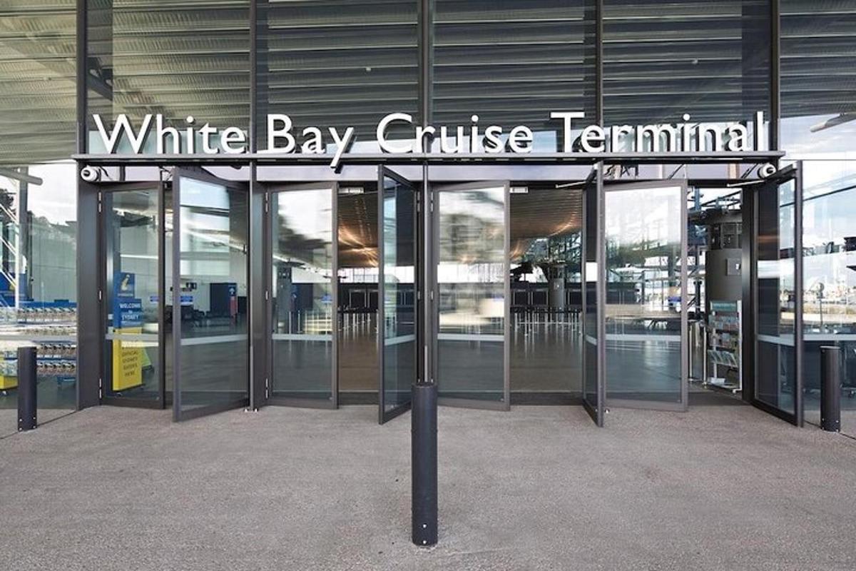 an entrance to a white bay cruise terminal with revolving doors