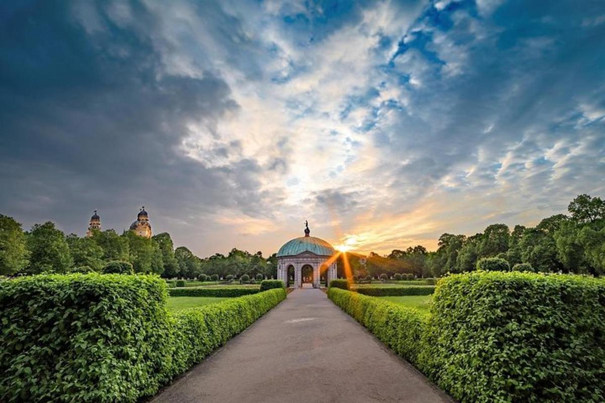 un edifici en un jardí amb una posta de sol al fons