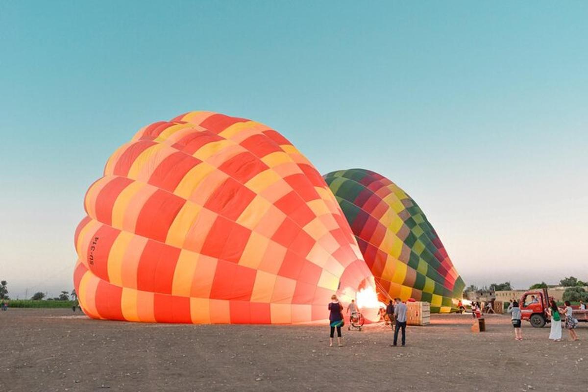drei Personen stehen vor drei Heißluftballons