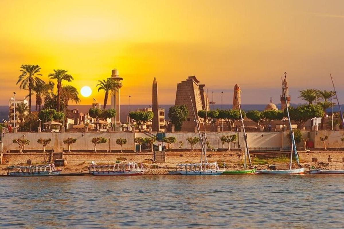 Una puesta de sol sobre una ciudad con barcos en el agua.