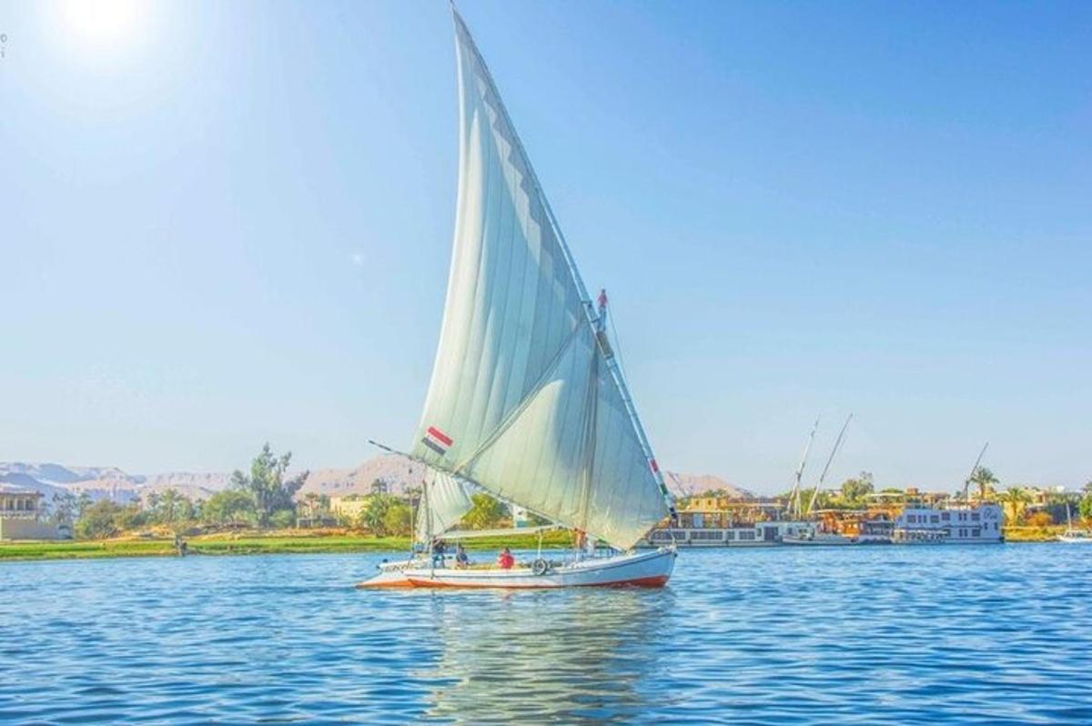 a boat with a large sail on the water