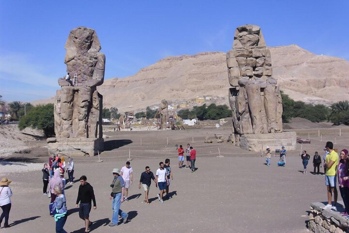 Un grupo de personas caminando alrededor de la estatua de dos estatuas.