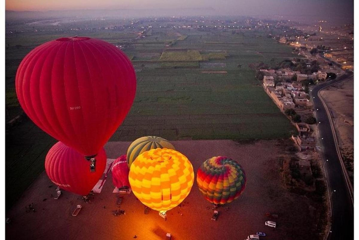 sekelompok balon udara panas terbang di atas sebuah ladang