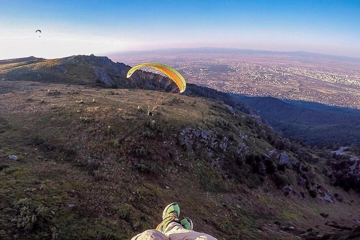شخص يطير بمظلة على قمة جبل