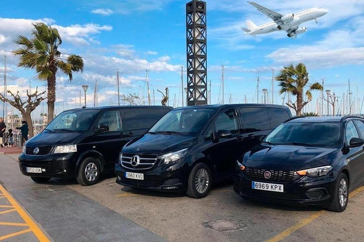 tři auta zaparkovaná na parkovišti s letadlem