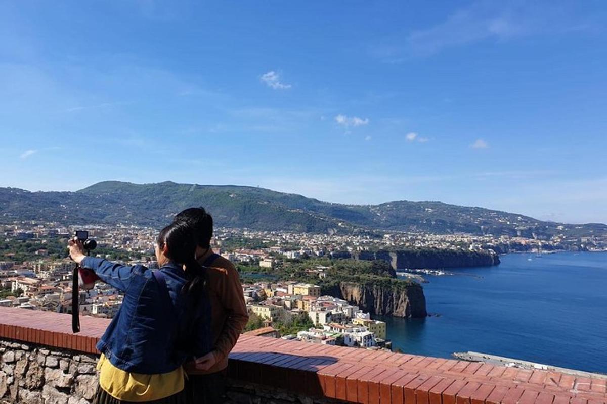 una donna che scatta una foto di una vista dell'oceano
