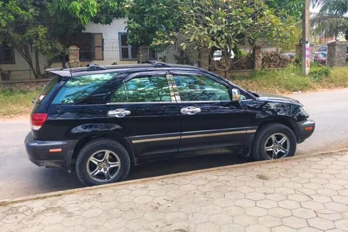 un'auto nera parcheggiata sul ciglio di una strada