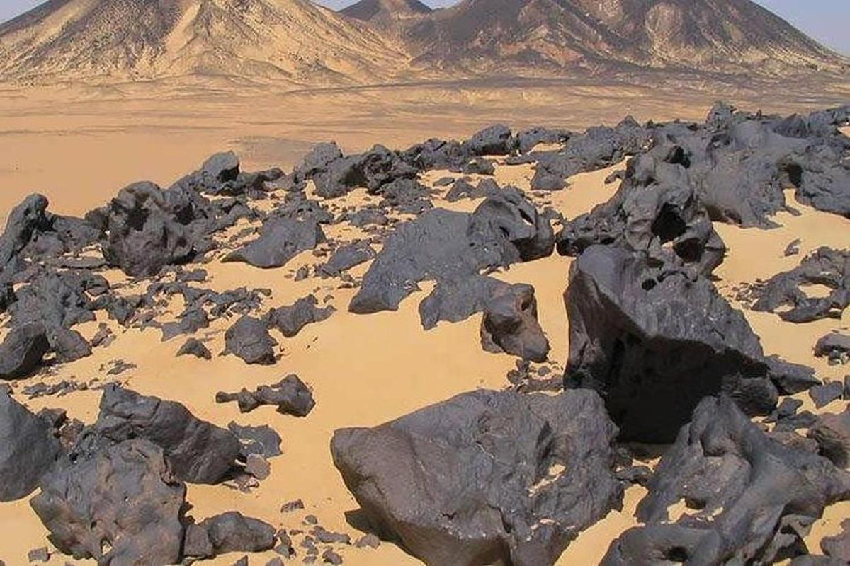 a desert with rocks and a mountain in the background