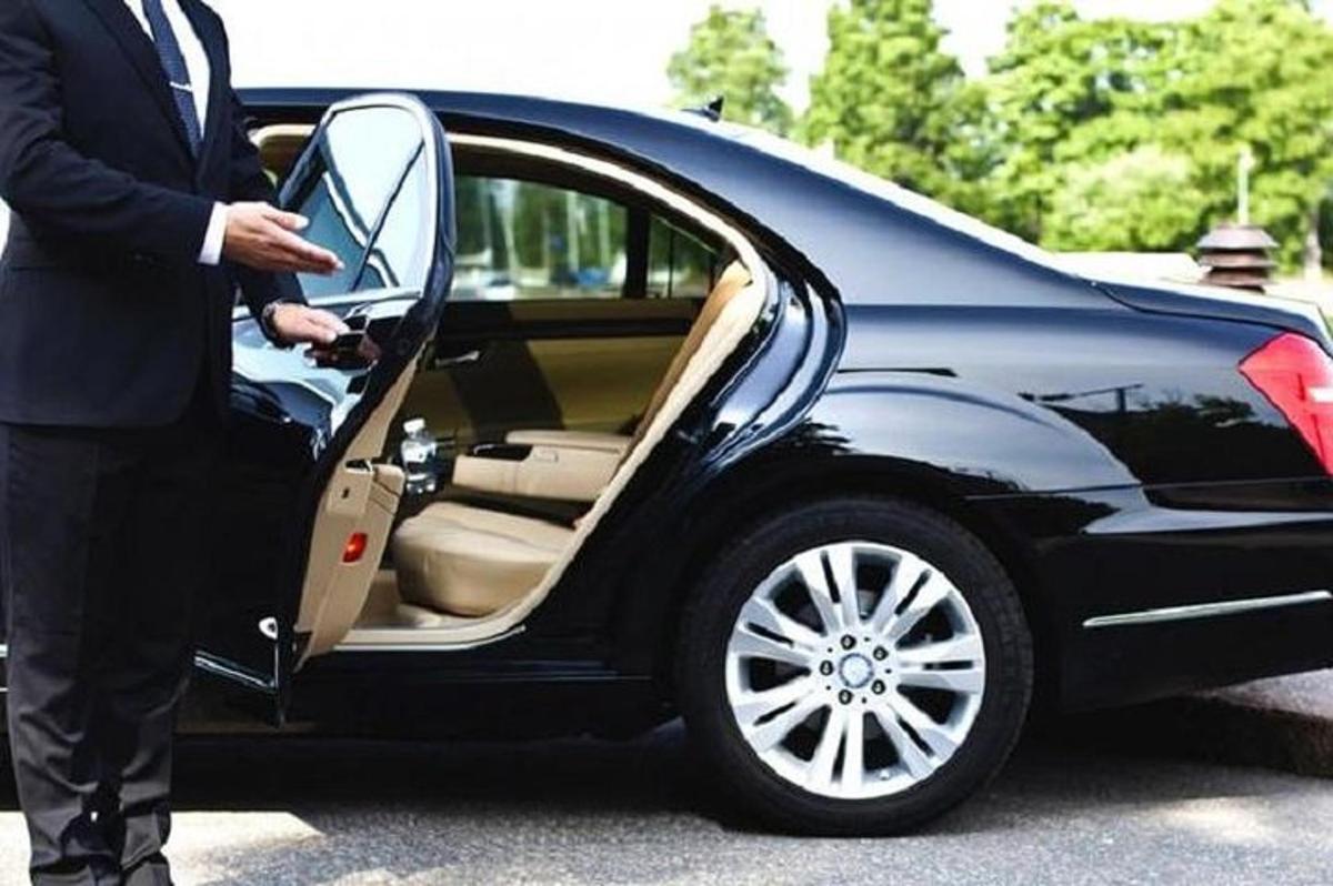 um homem abrindo a porta de um carro preto