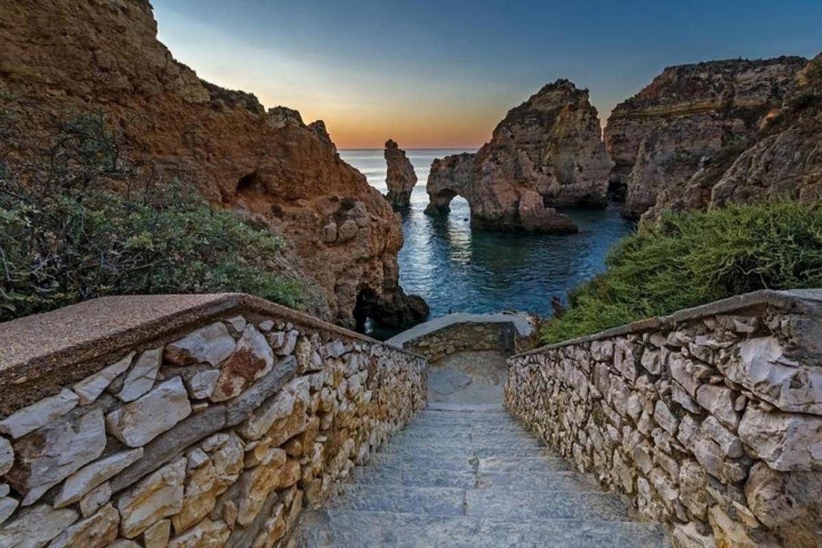 un camí de pedra al costat d'una paret de roca al costat de l'oceà