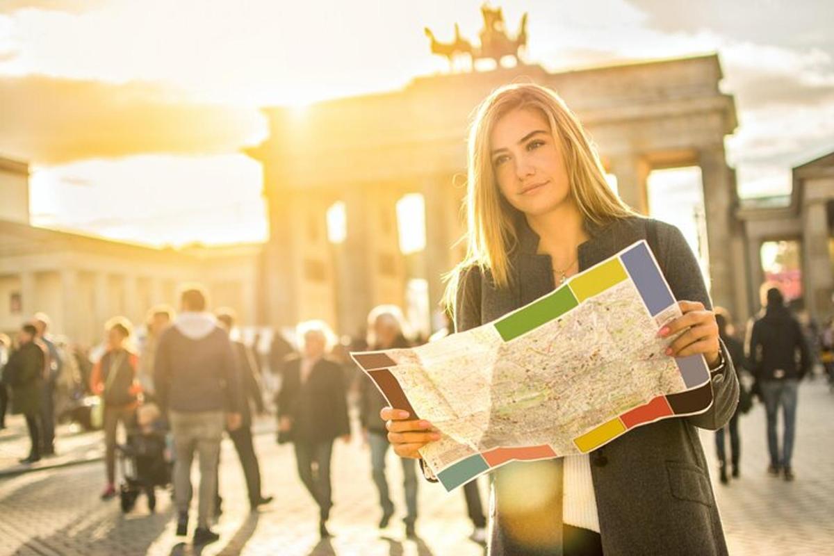 Una mujer sosteniendo un mapa entre una multitud de personas.