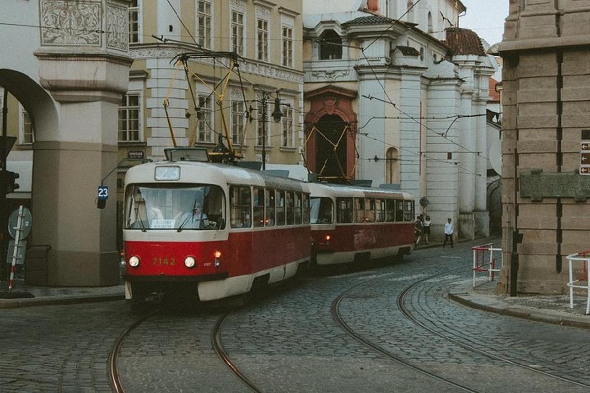 două trenuri roșii și albe pe șine într-un oraș
