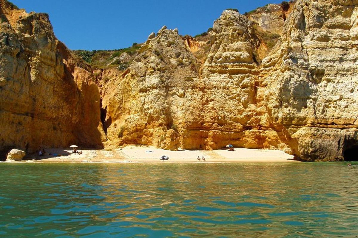 una playa junto a un gran acantilado rocoso