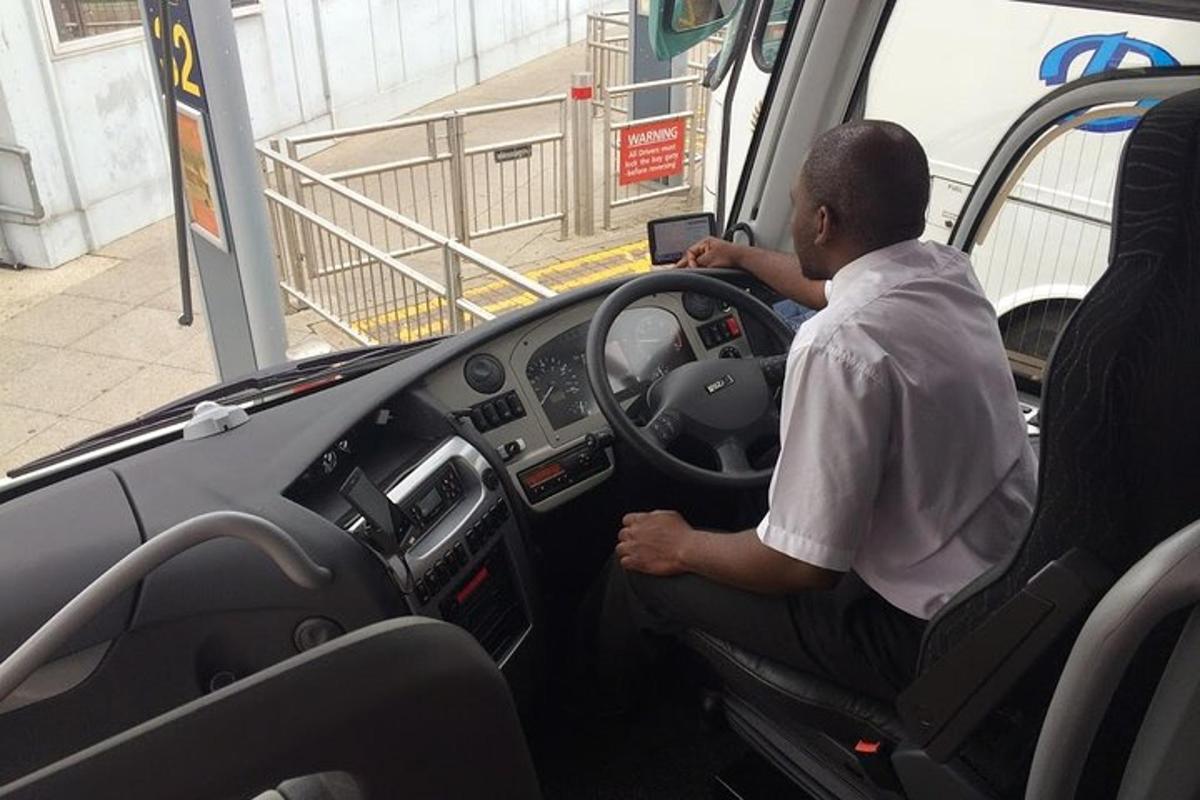muž sedící na sedadle řidiče autobusu