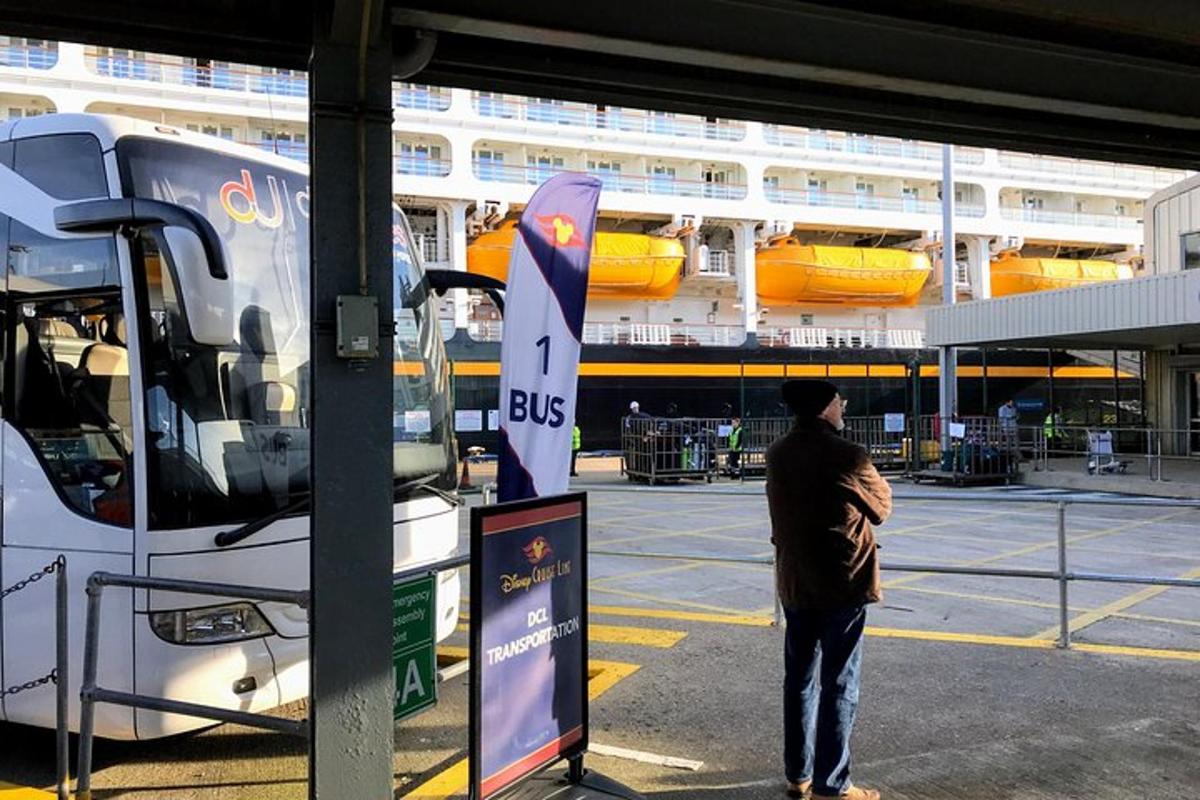 egy férfi a buszmegállóban áll egy busz mellett