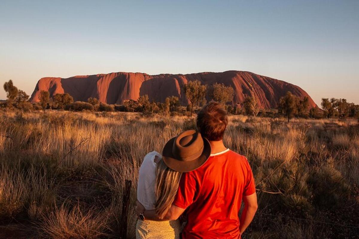 Moški in ženska gledata na Ayers Rock