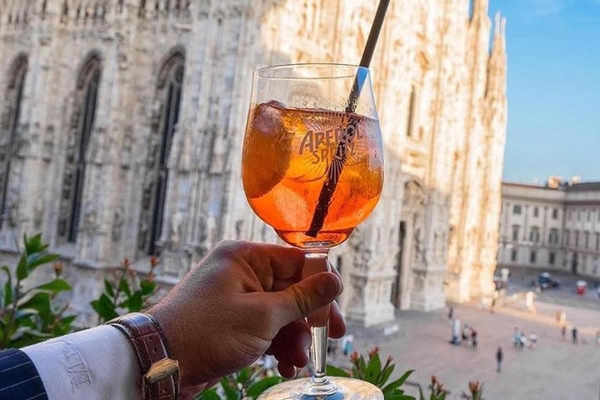 una persona sosteniendo una copa de vino frente a un edificio