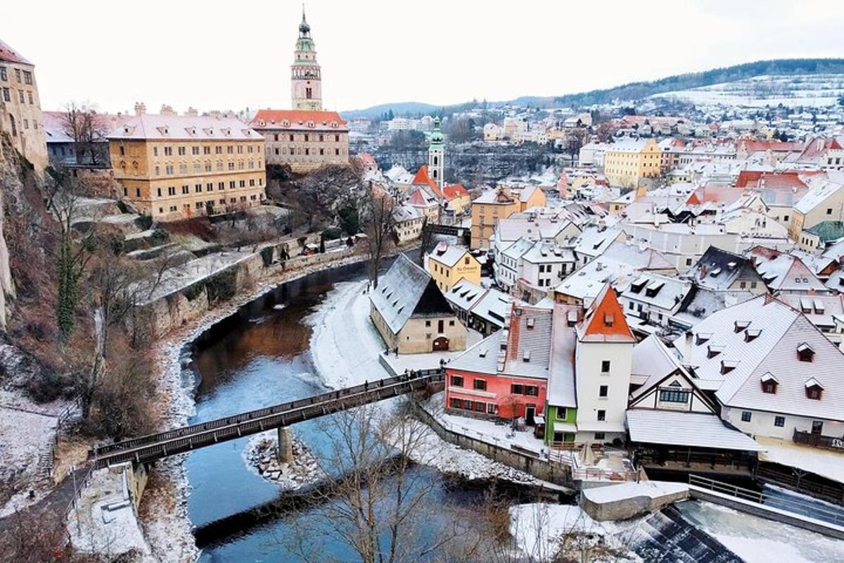 una ciutat amb un pont i teulades cobertes de neu