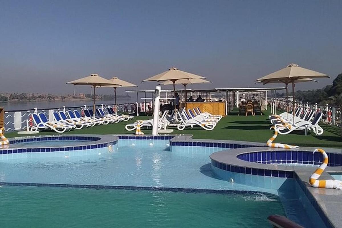 una gran piscina con sillas y sombrillas