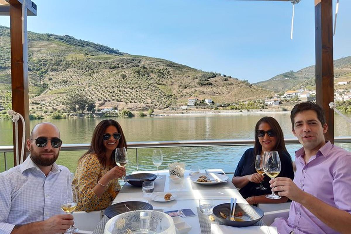 Un grupo de personas sentadas en una mesa con copas de vino.