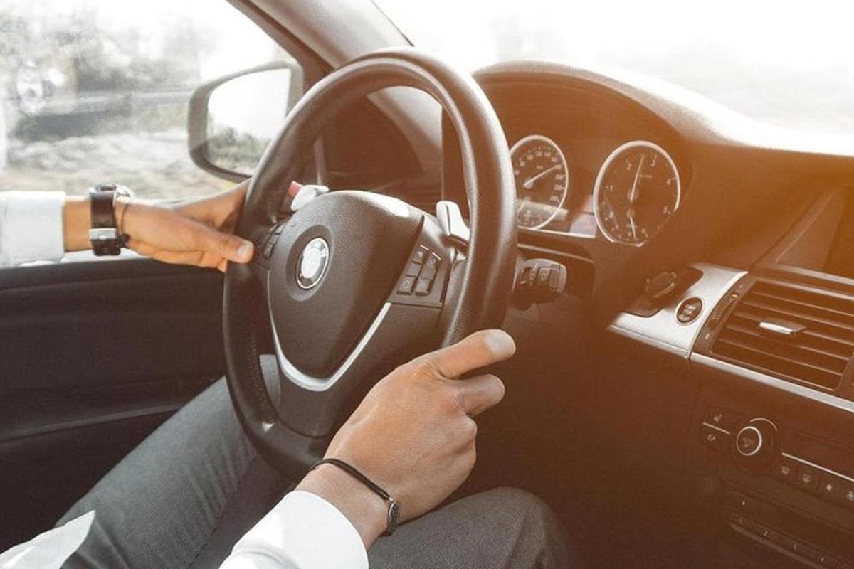 une personne conduisant une voiture avec les mains sur le volant