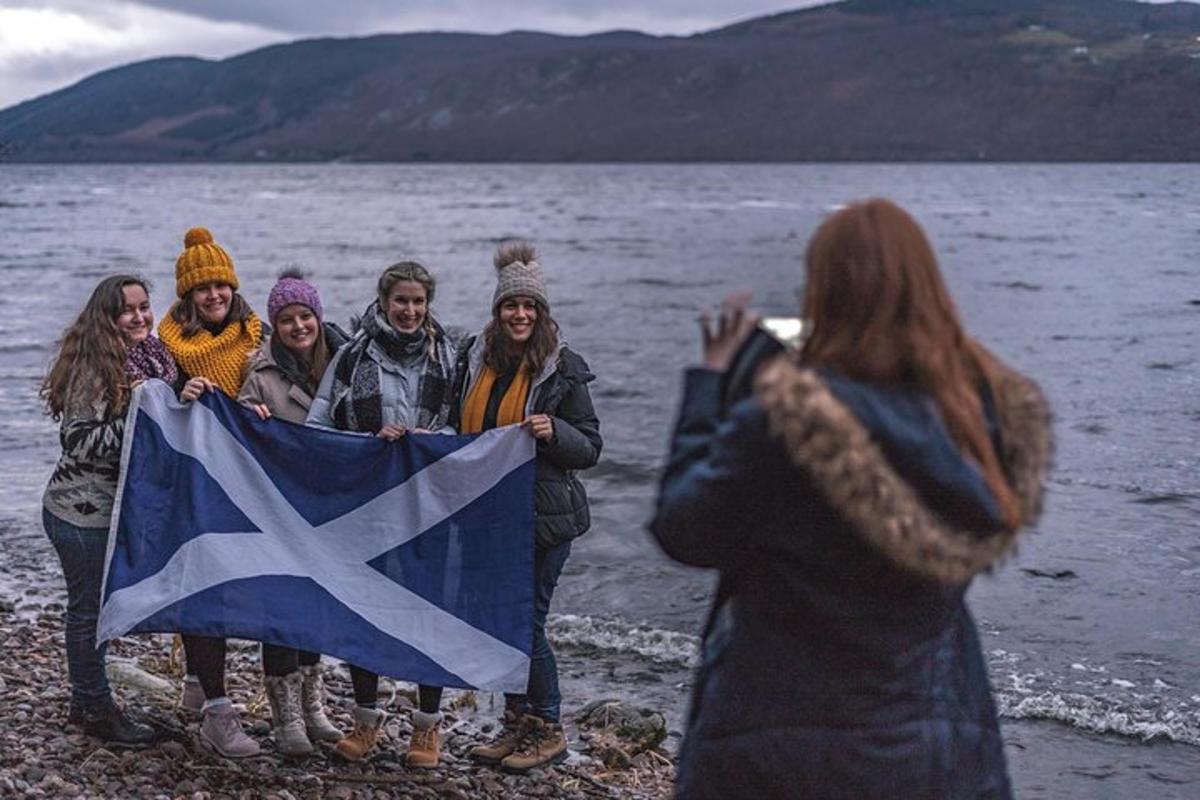 a group of people standing on the beach holding a flag
