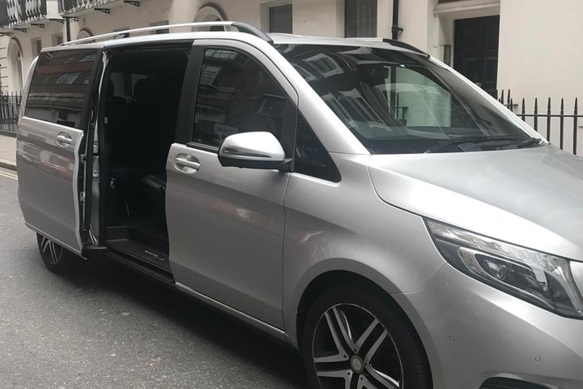 a silver van with its door open on a street