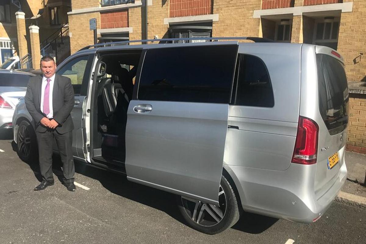 a man in a suit standing next to a van
