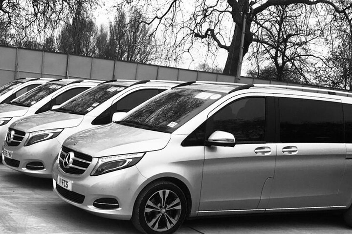 a row of parked vans parked in a parking lot