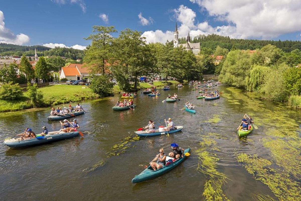 un grup de oameni care navighează cu caiacul pe un râu în canoe